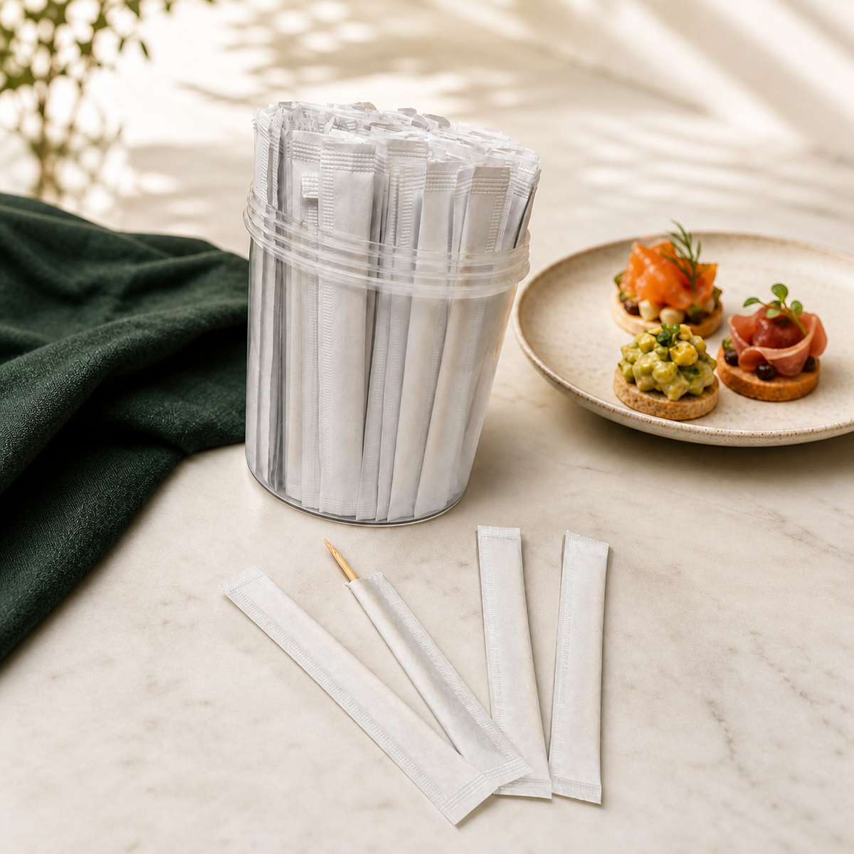 Paper-wrapped toothpicks beside a clear dispenser