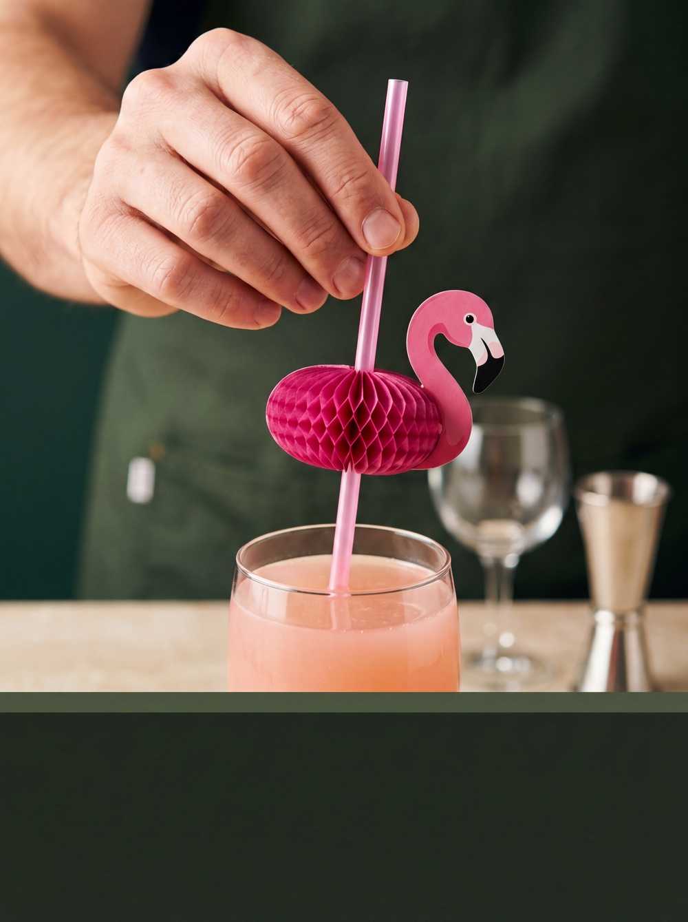 Flamingo decorative drinking straw being placed in a cocktail